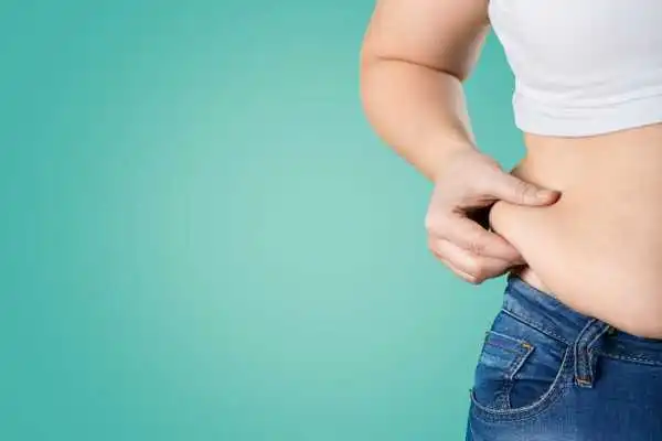 Image of woman pinching her love handles to show weight gain Kingston upon Thames
