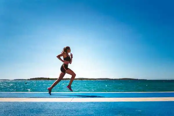 Woman running showing strong leg muscle Kingston upon Thames